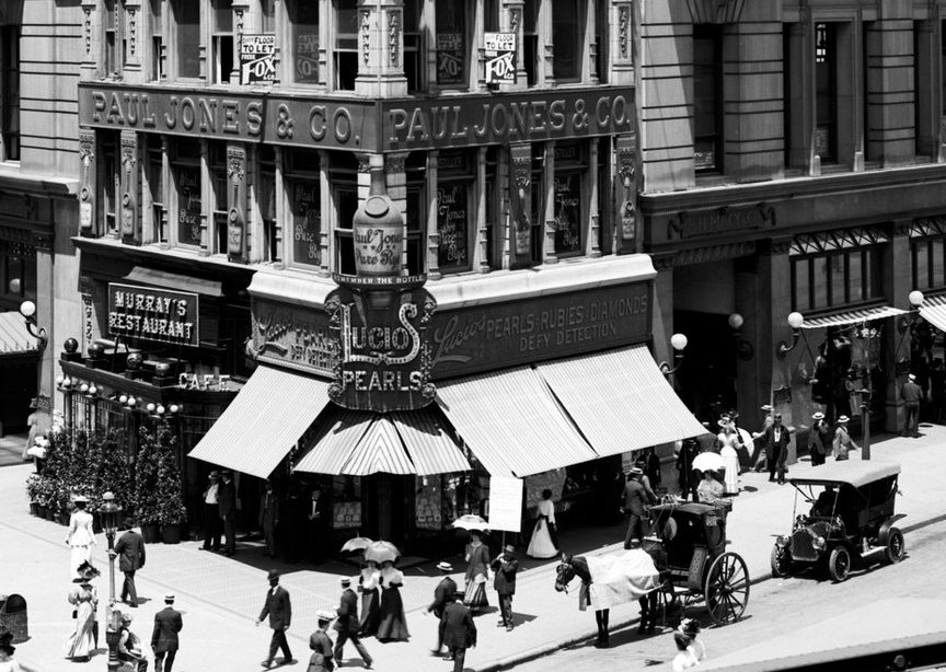 Shoppers at the corner doors and awnings on Herald Square.
